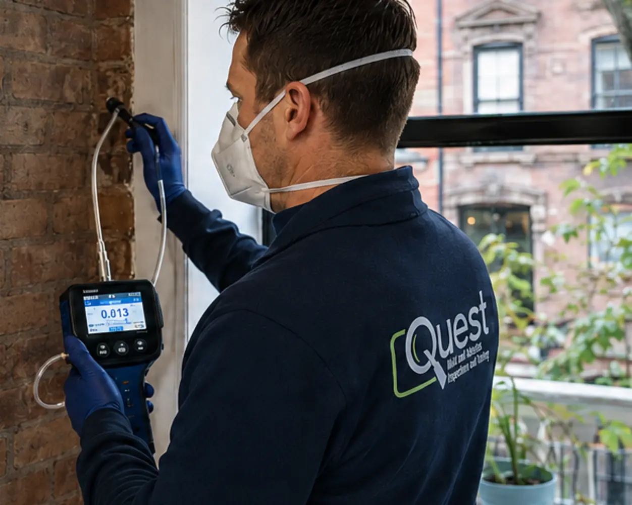 Quest inspector evaluating an interior wall with testing equipment